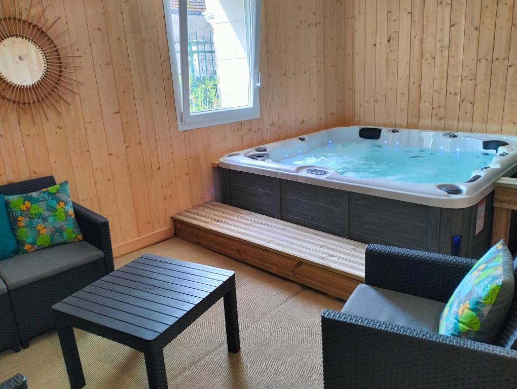 a jacuzzi tub in a room with a table and chairs at Gîte la Bourgeoise in Bléré