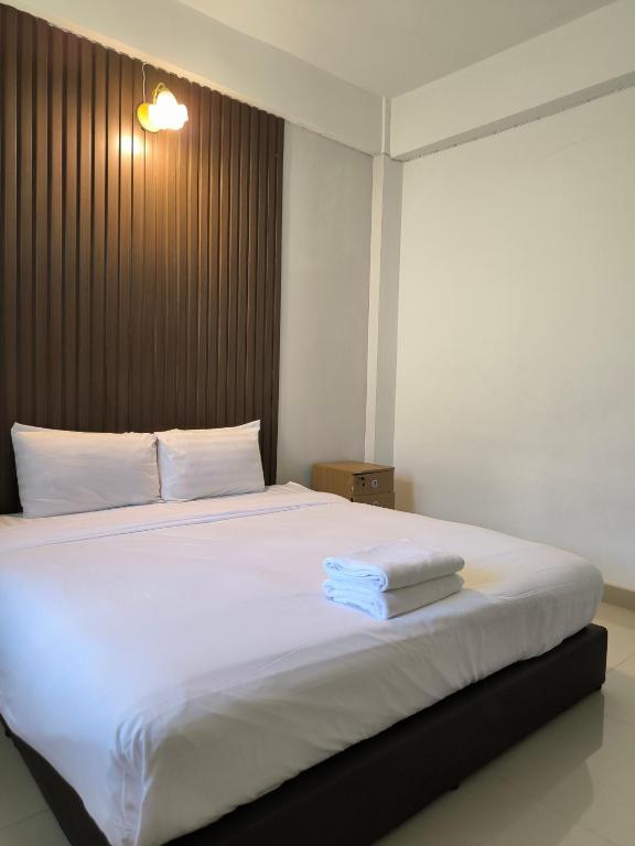 a bedroom with a large white bed with two towels on it at SB The Moon Night Betong in Betong