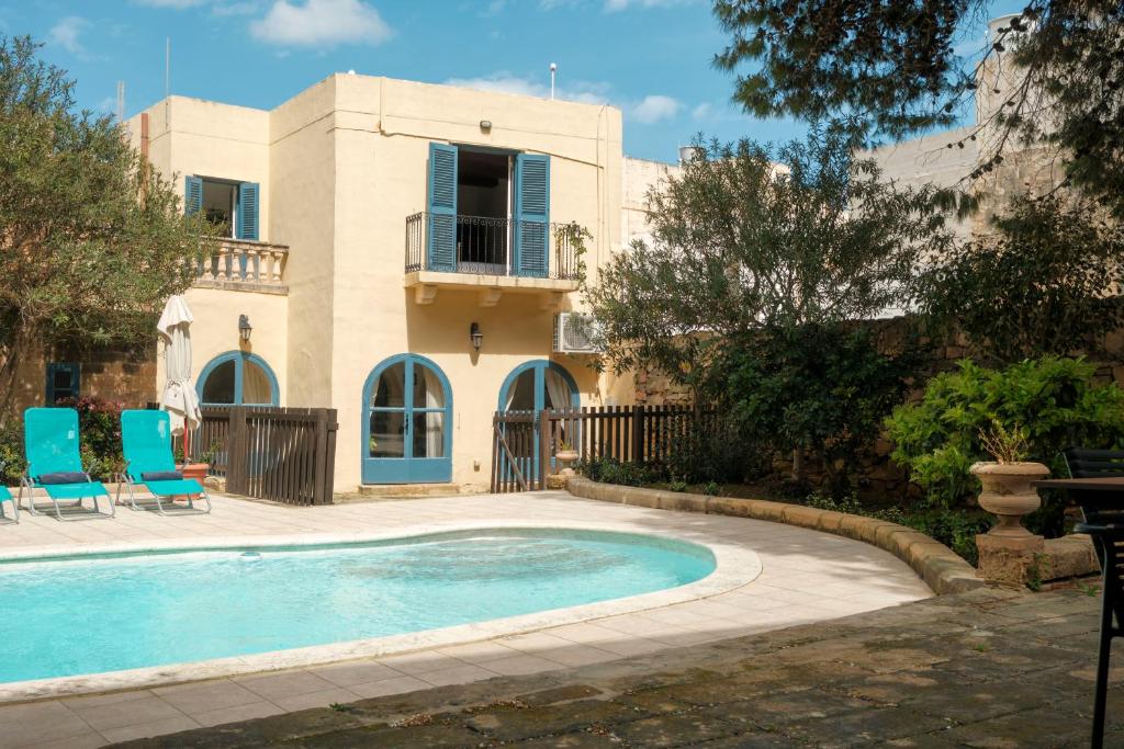 a villa with a swimming pool in front of a house at Historic Villa with a Private Pool in Mosta