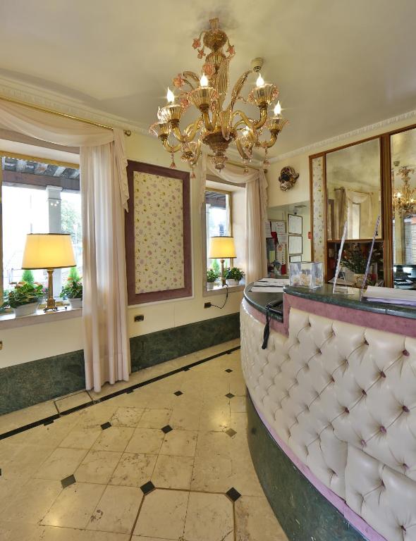 a large room with a chandelier and a counter at Hotel Arlecchino in Venice