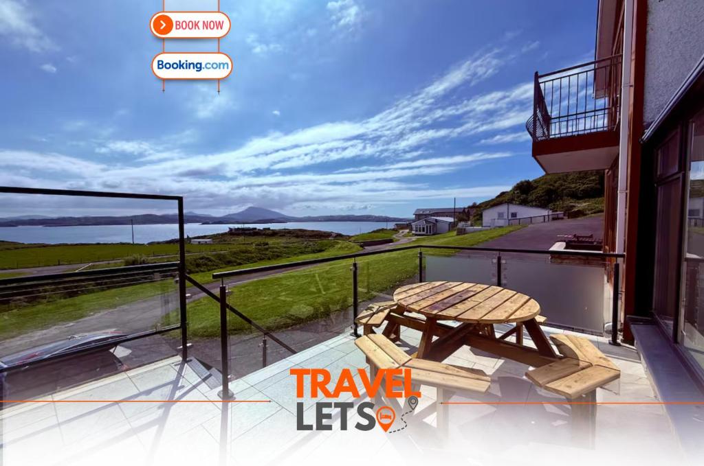 a balcony with a table and a view of the ocean at Two Bedroom House By Travel Lets Self Catering Accommodation Downings With Atlantic View in Downings