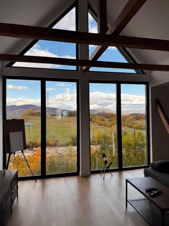 a room with large windows with a view of the mountains at Sunset Hills Chalet in Slănic