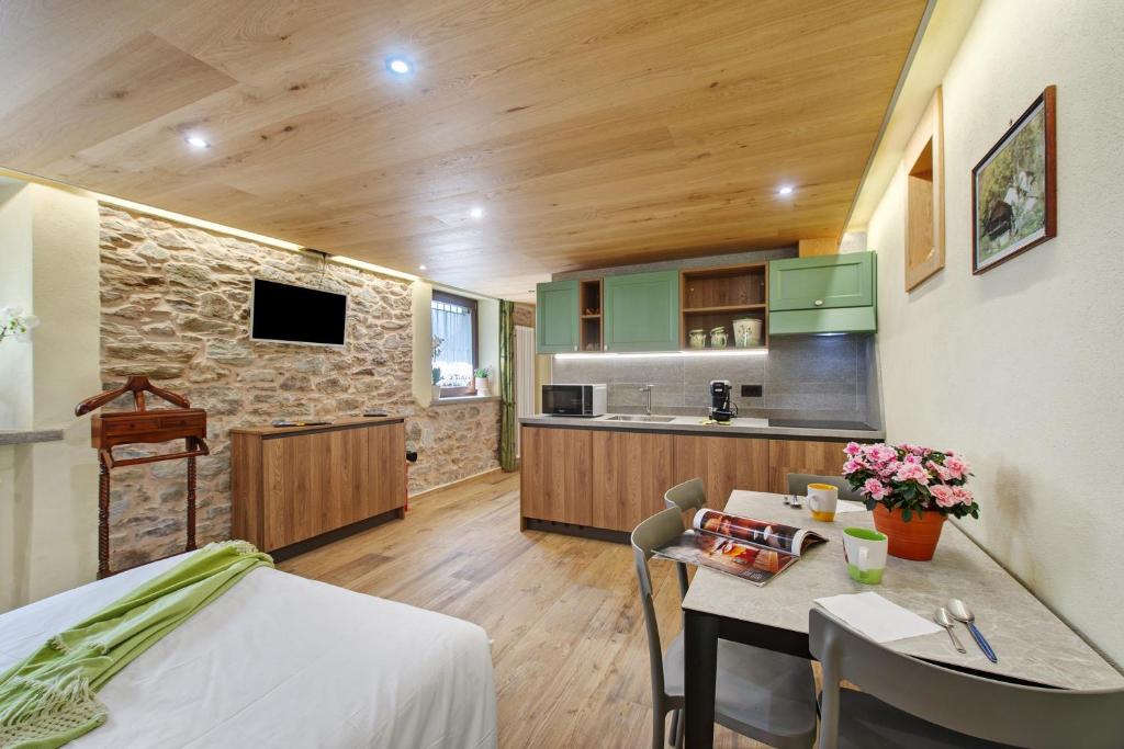 a kitchen and living room with a table and chairs at Mes Anges Perloz in Pont-Saint-Martin