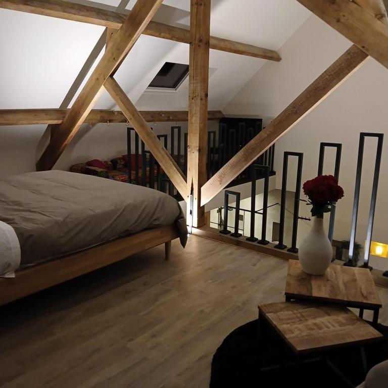 a bedroom with a bed and a table with a vase of flowers at Celessentielle à 10 min de Pairi Daiza , gîte romantique in Jurbise