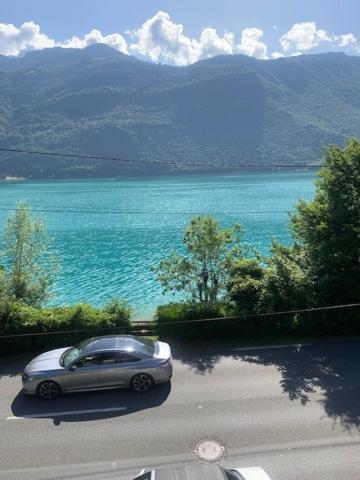 a silver car parked on a road near the water at lake view chalet Doussard Annecy in Doussard