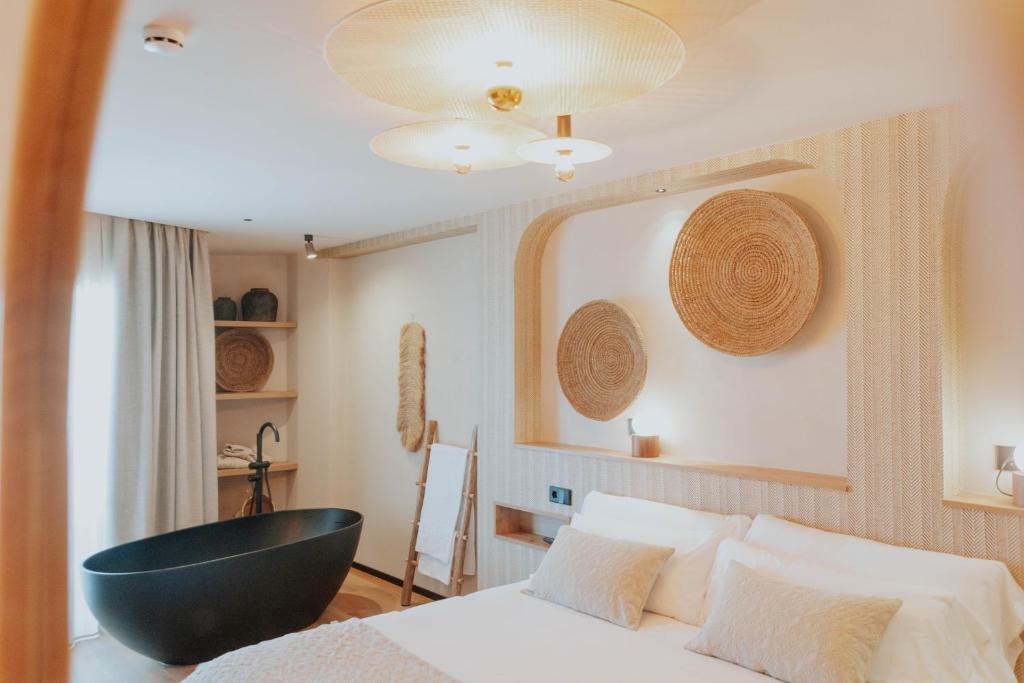 ein Schlafzimmer mit einem Bett und einer schwarzen Badewanne in der Unterkunft Hotel Meridional in Guardamar del Segura