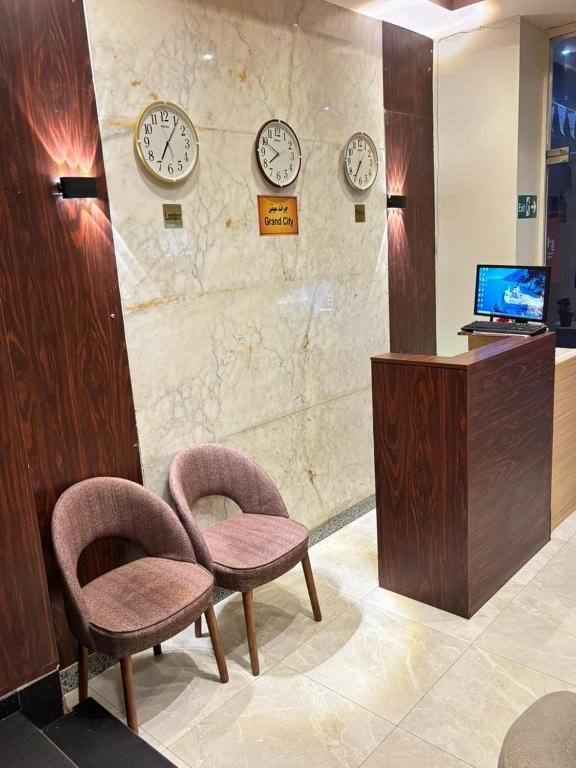 a waiting room with two chairs and clocks on the wall at Grand Elite Hotel in Cairo