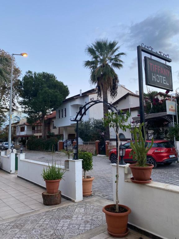 a sign for a hotel on a street with plants at Tiffany Otel in Özdere