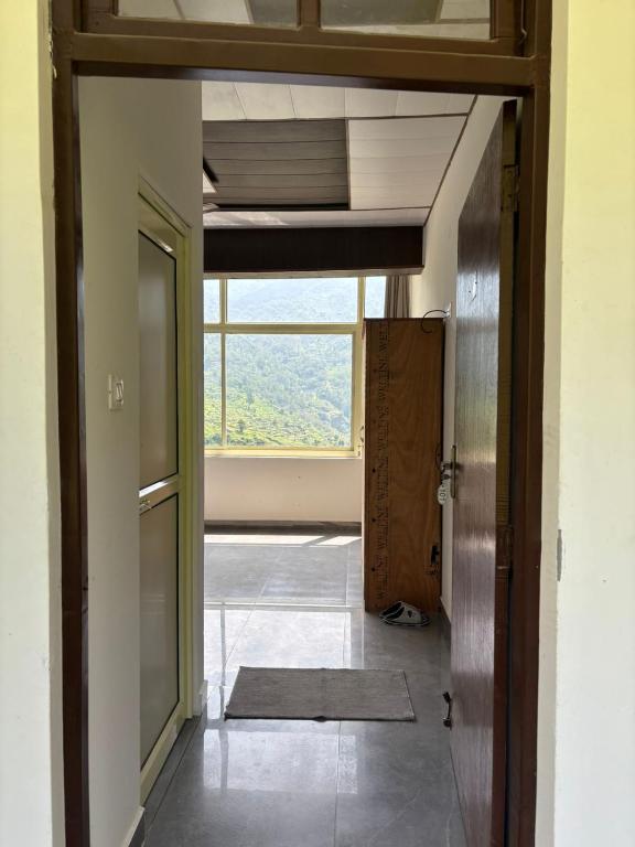 an open hallway with a door and a window at The Jade Inn in Gopeshwar