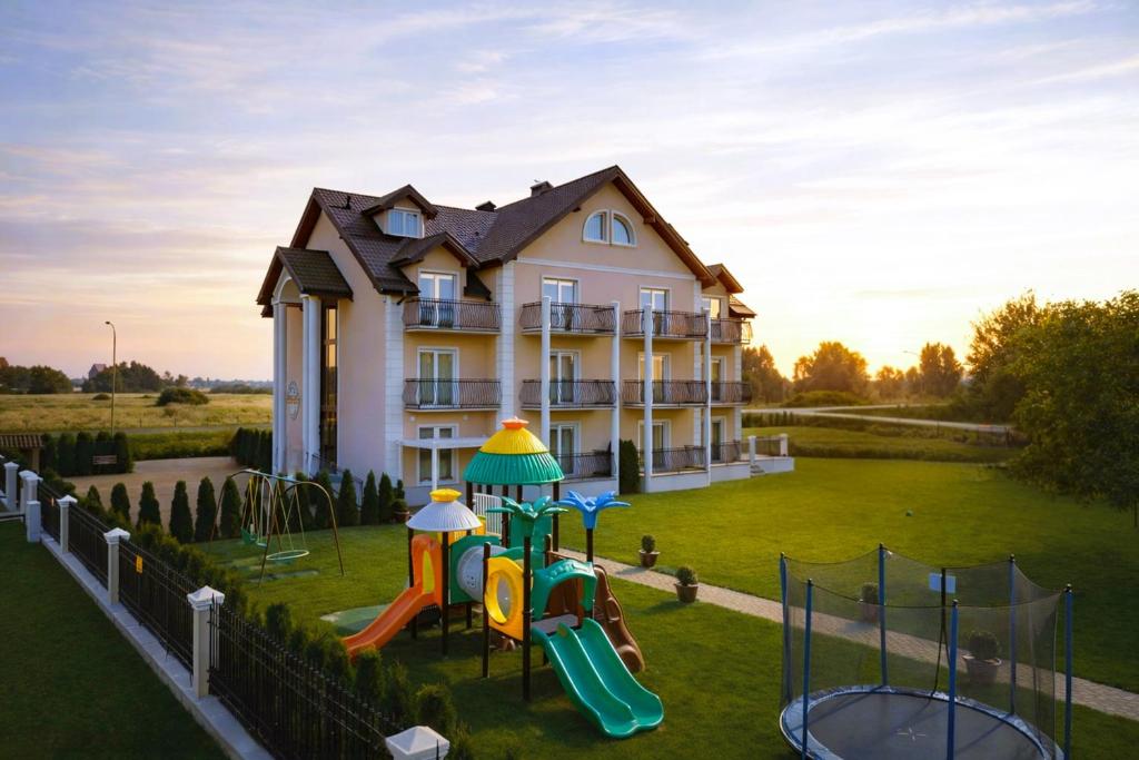 a house with a playground in front of a house at Pensjonat Marynarski - Apartamenty in Darlowko