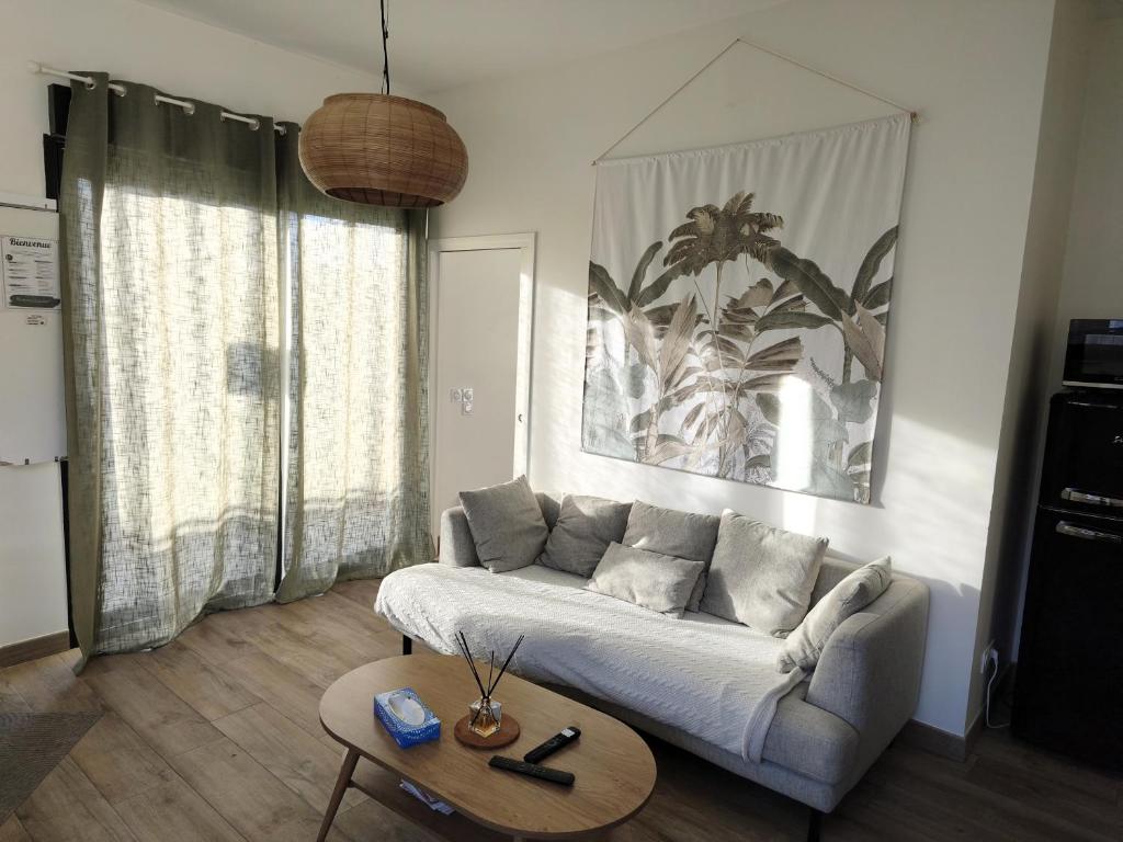 a living room with a couch and a table at Maison cosy et élégante -Tram A et E à 300 m, - Bordeaux 15 min in Cenon