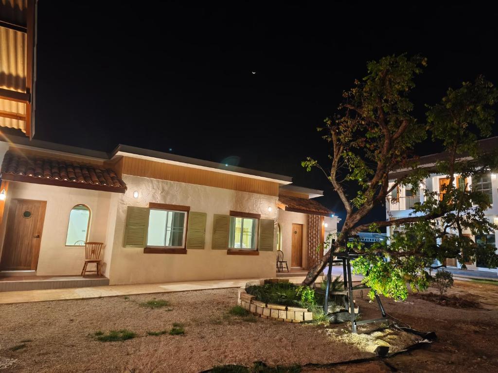 a house with a tree in front of it at night at เดอะมูนไลท์วิลล่าพะเยา in Phayao