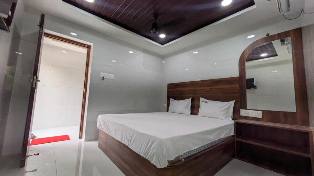 a bedroom with a large bed and a mirror at Abidharpp in Velankanni
