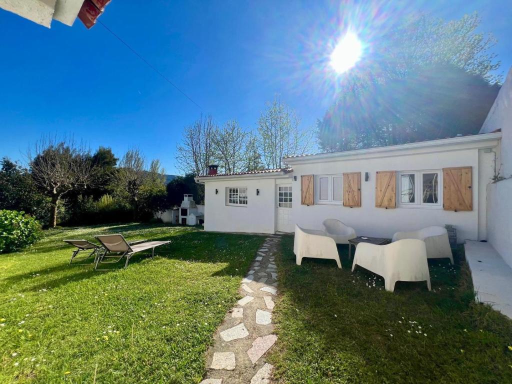 a white house with a table and chairs in the yard at Casa La Finca in Vigo