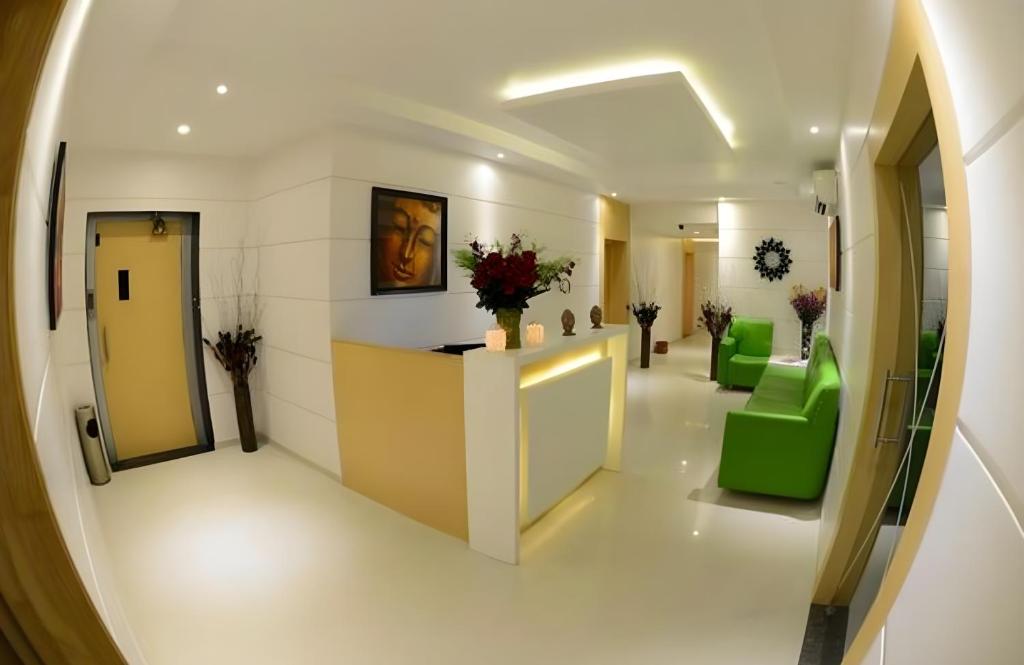 a hallway with a waiting room with green chairs at Hotel Anantha Suites in Sitam Petta