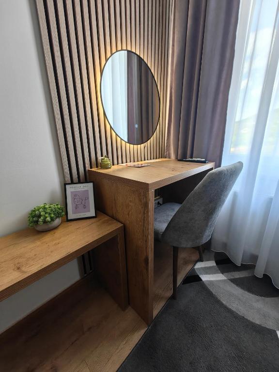 a desk with a mirror and a chair in a room at Motel Maks in Kiseljak