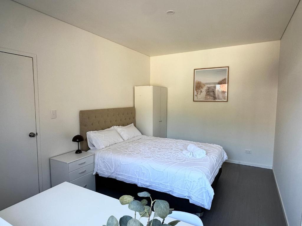 a small bedroom with two beds and a night stand at June Stay in Perth