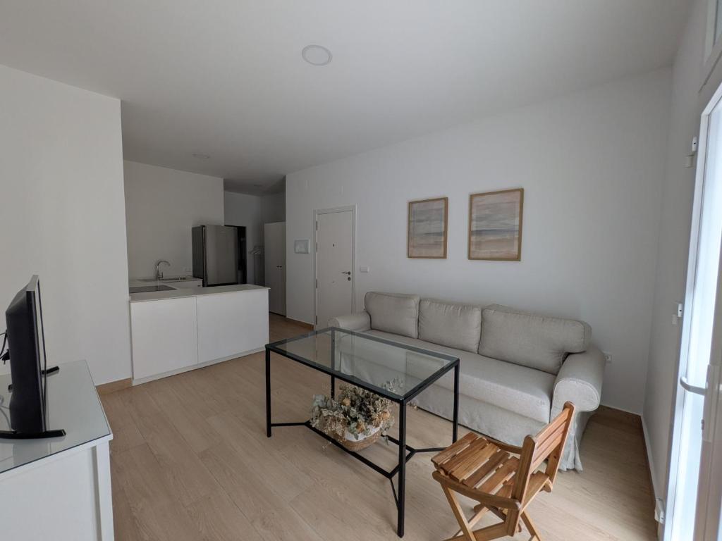a living room with a couch and a glass table at Apartamento Calle Bolsa in Sanlúcar de Barrameda