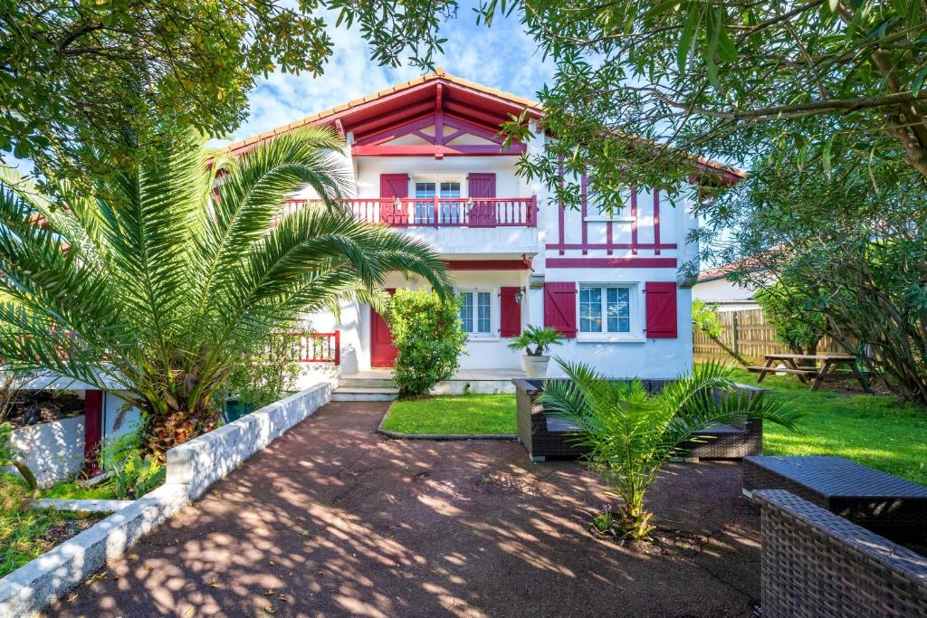 a home with a red and white house with trees at Chambre d'hôtes d'Émilie in Anglet