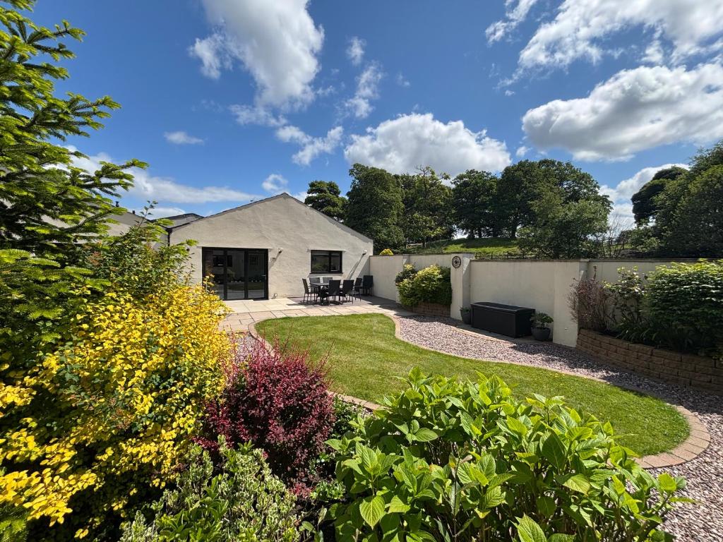 a garden with a house and a fence at Hodder Cottage in The Ribble Valley in Whalley