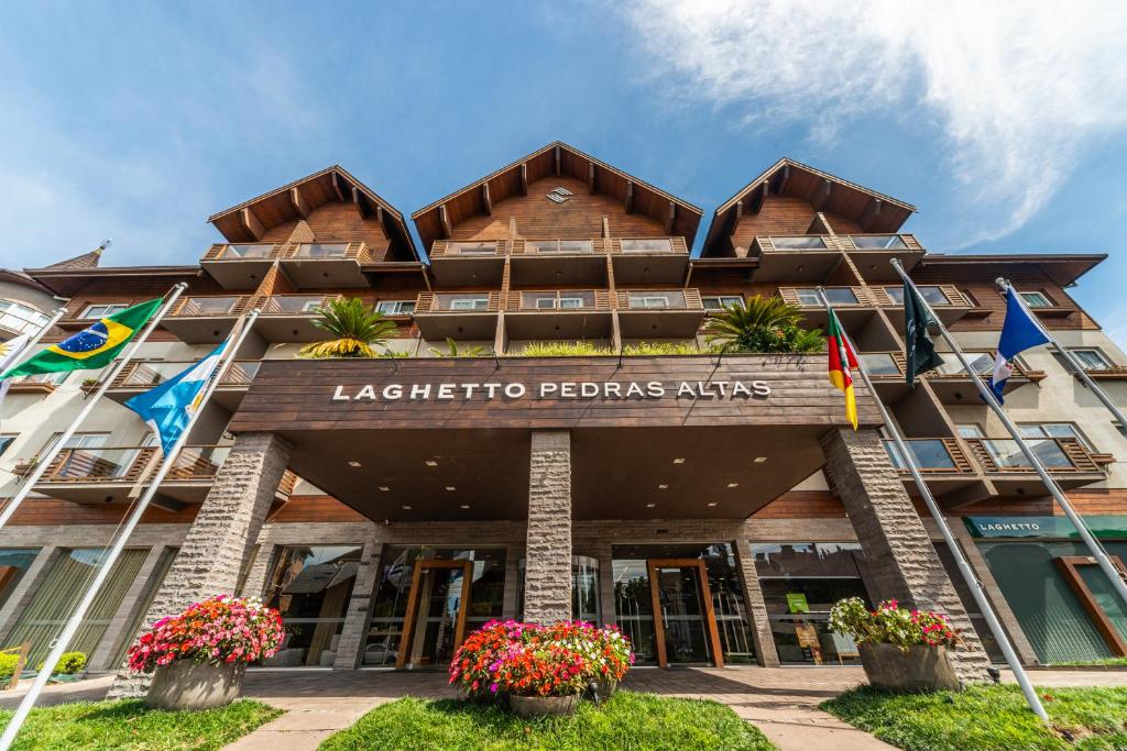 a building with flags in front of it at Hotel Laghetto Pedras Altas in Gramado