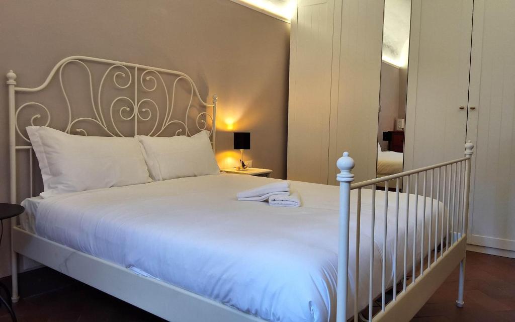 a bedroom with a white bed and a mirror at Sky Loft La Melissa - Pisa Center in Pisa