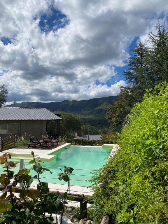 a swimming pool with mountains in the background at La Empinada in Bialet Massé