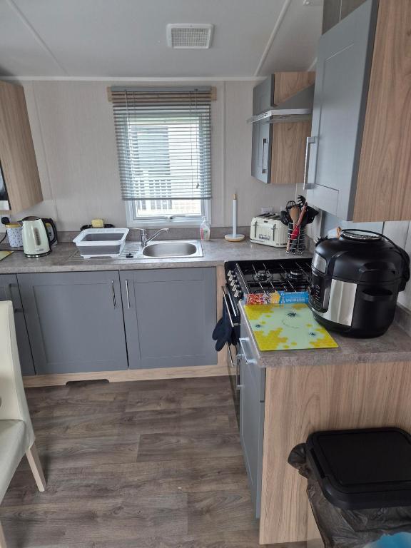 a small kitchen with a stove and a sink at Sharmar Eyemouth in Eyemouth