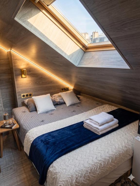 a bedroom with a large bed with a skylight at La'Mansarda in Chişinău