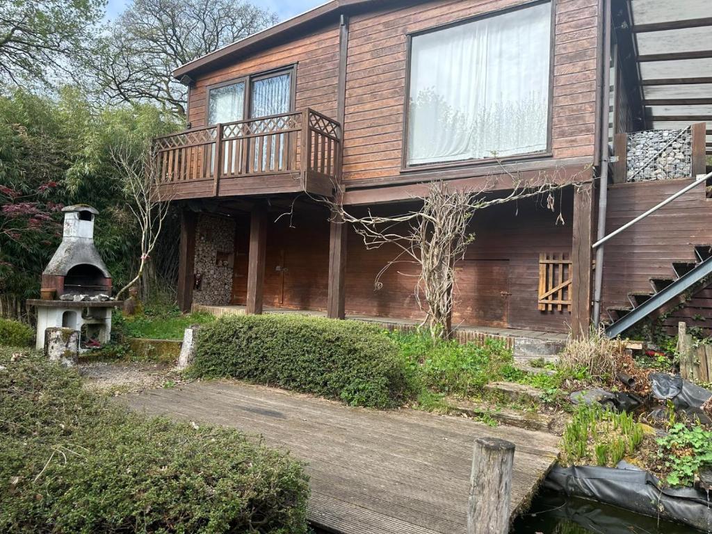 a house with a deck and a wood porch at Lilia Chalet in Durbuy