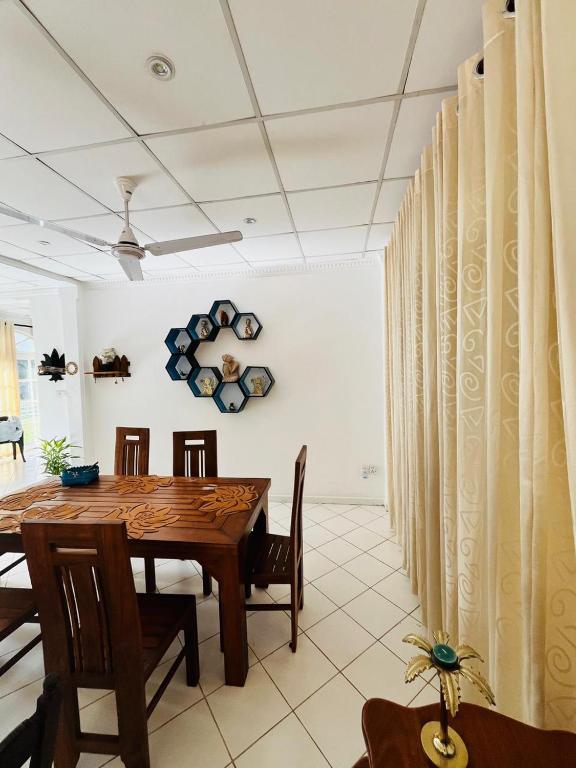 a dining room with a wooden table and chairs at Benthota grand villa in Nakandalagoda
