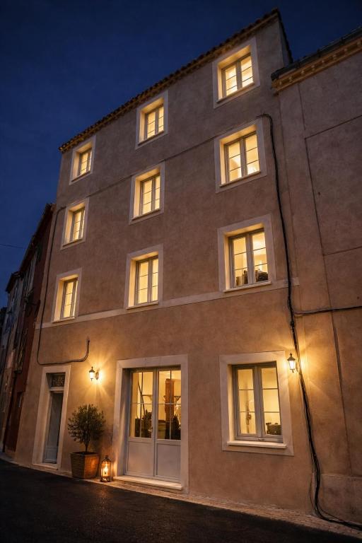 a large brick building with lit windows at night at Trianon Location in Bagnols-en-Forêt