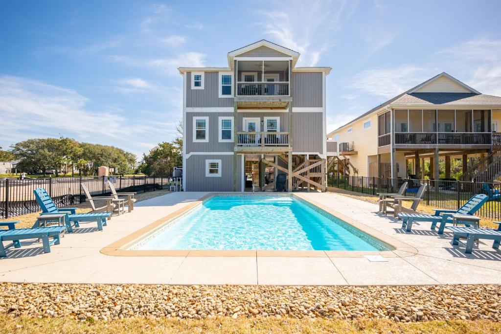 a villa with a swimming pool and a house at Beach 45 by Oak Island Accommodations in Oak Island