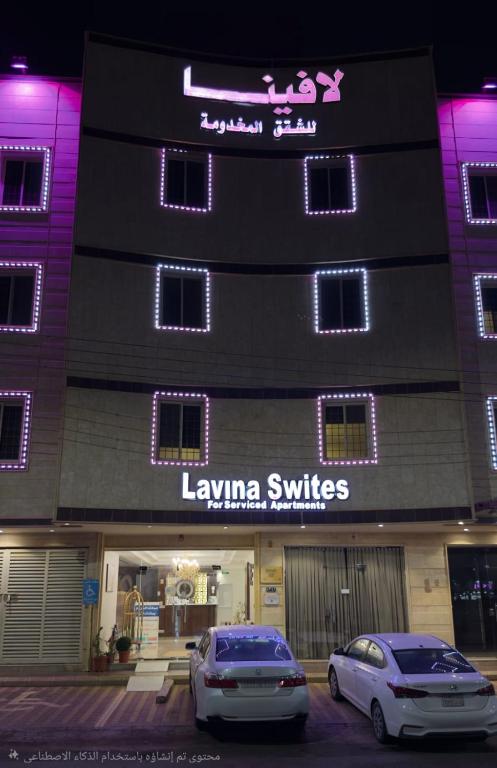 two cars parked in front of a building with purple lights at شقق لافينا للوحدات السكنية - المخدومة - اقتصادي in Hail