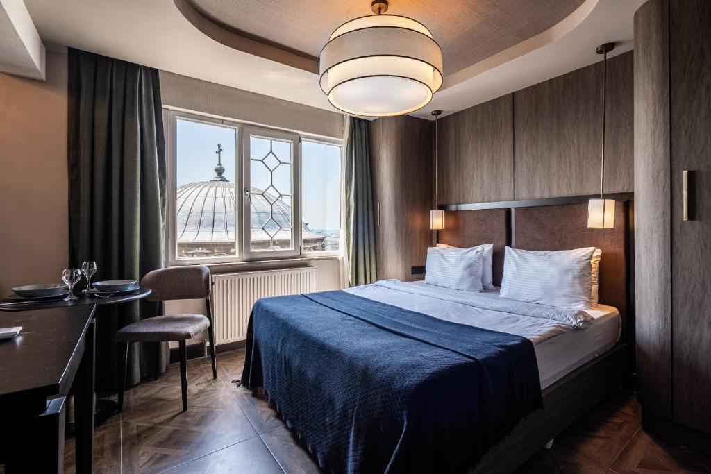 a hotel room with a bed and a desk and a window at Sayeban Hotel Istanbul in Istanbul