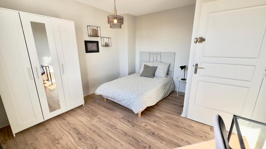 a small bedroom with a bed and a mirror at Maison en colocation, 2 salles de bains & WC, Wifi, Parking, proche CHU & Limoges in Isle