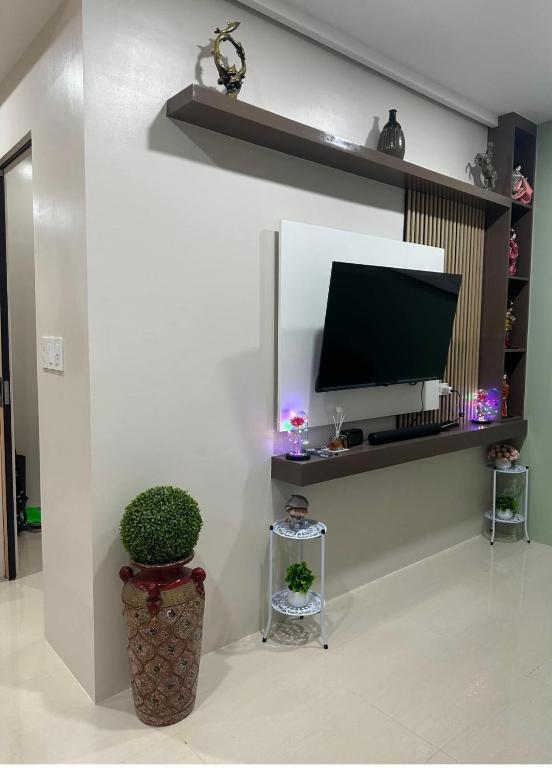 a living room with a flat screen tv on a wall at UrbanGem Iloilo in Iloilo City