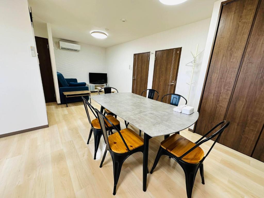 a dining room with a table and chairs at つんまぁー家 in Miyakojima