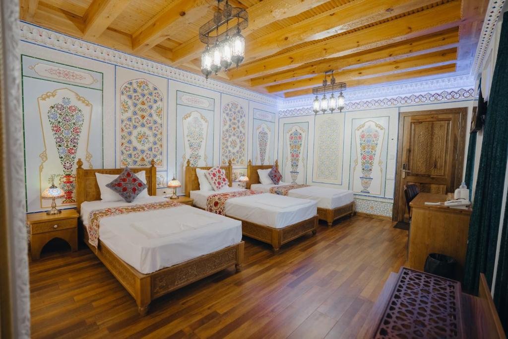 a bedroom with two beds in a room at Imranbek Boutique Hotel in Bukhara