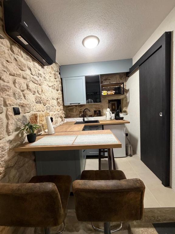 a kitchen with a table and some chairs in a room at Dragazzo studio in Trogir
