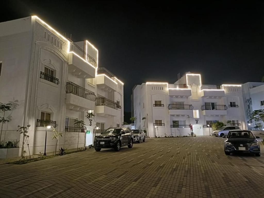 a parking lot in front of a large building at night at منتجع هدب للشقق المخدومة in Taif