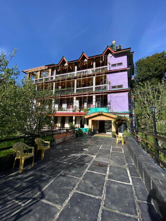a large building with a stone walkway in front of it at Nature Nest in Manāli