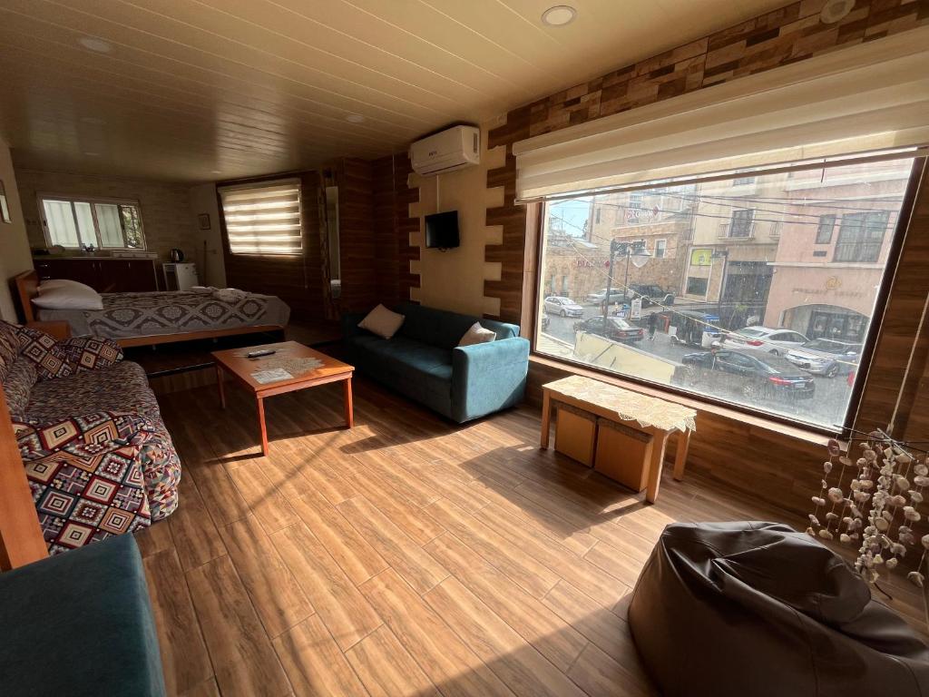 a living room with a couch and a large window at Batroun Souq, Perfect location, 1 Bedroom in Batroûn