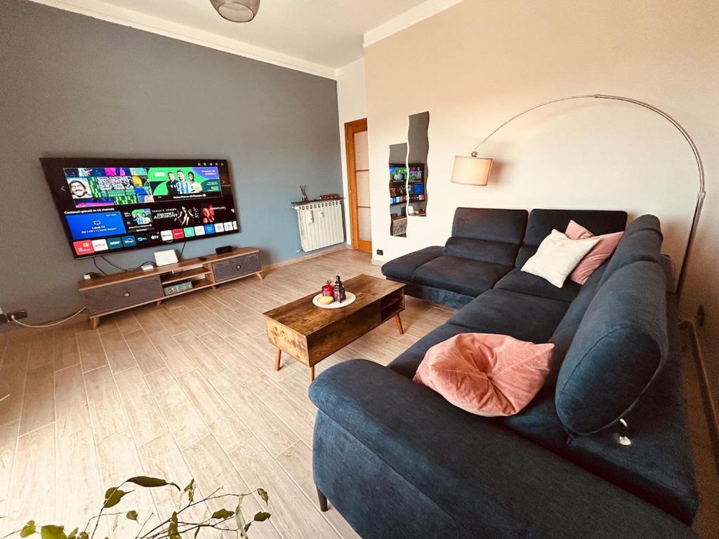 a living room with a blue couch and a flat screen tv at Panoramic Terrace & Sea View Flat with Free Parking in Genoa