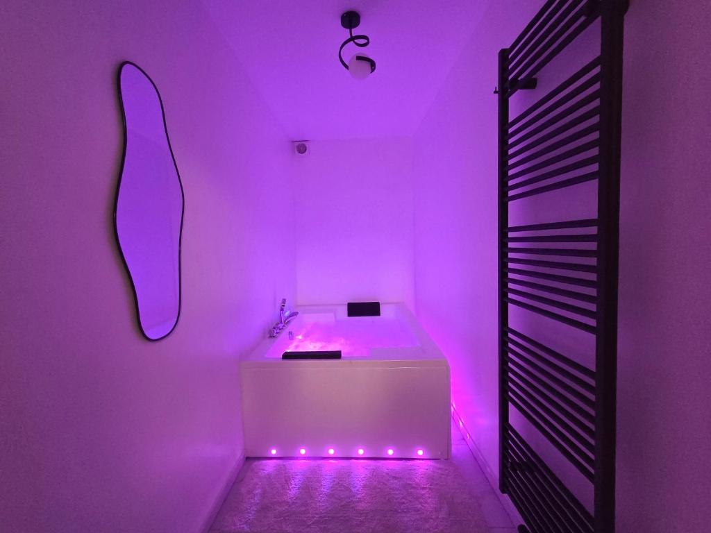 a bathroom with purple lighting and a white sink at Suite Design Balnéo - Lit King size - Garage privé in Tournai