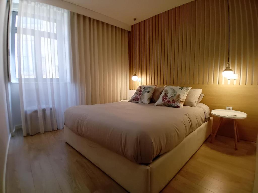 a bedroom with a large bed and a window at Da Valeta Ó in Arcos de Valdevez