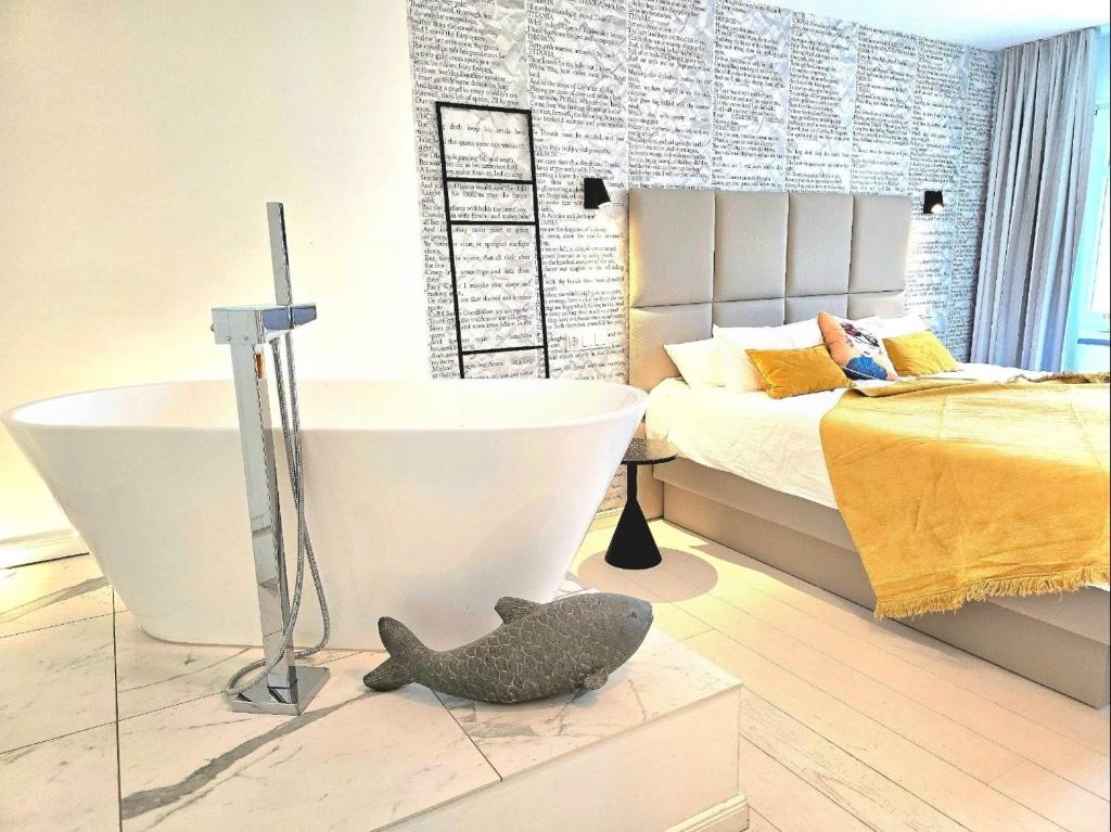 a bedroom with a bed and a bath tub next to a bed at Ferienwohnung Lieblingssuite am Strand in Ahlbeck