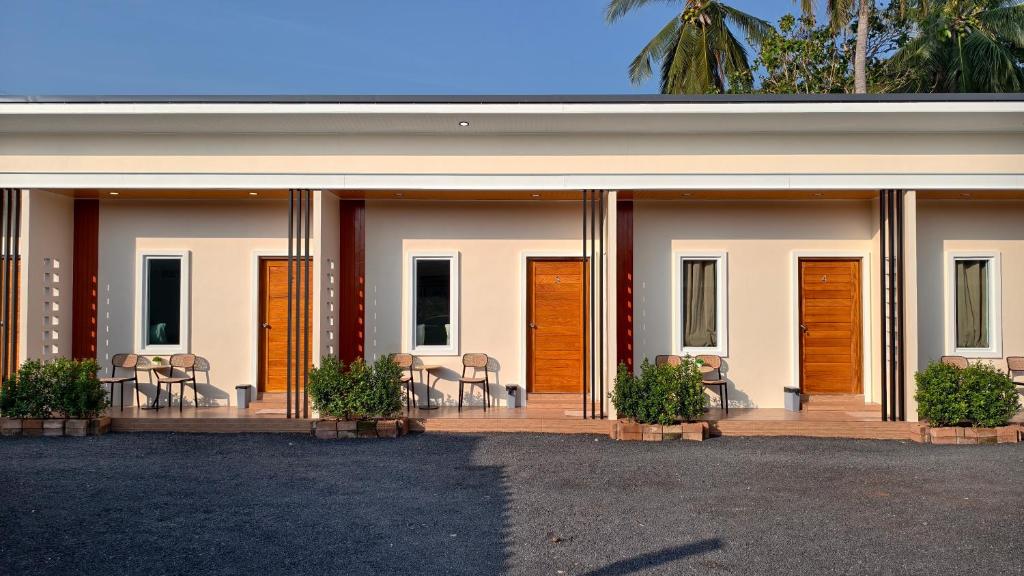 a building with wooden doors and chairs on a patio at ยินดีรีสอร์ท Yindee Resort in Don Sak