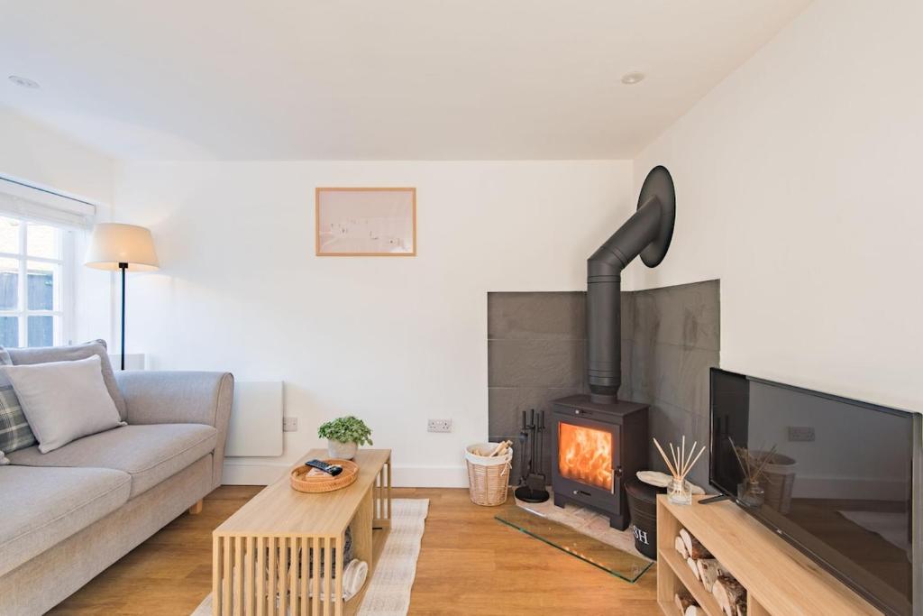 a living room with a couch and a fireplace at Crafters Cottage in Sandwich