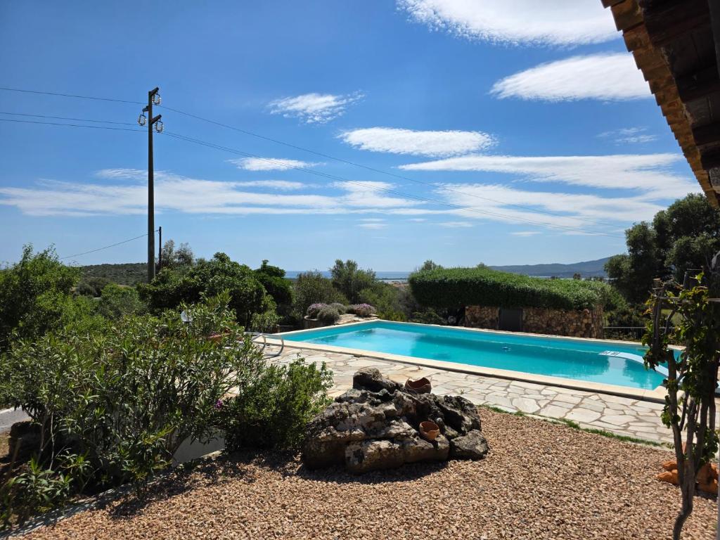 a swimming pool in a yard with a landscaping at Villa Altora in Nuragheddu
